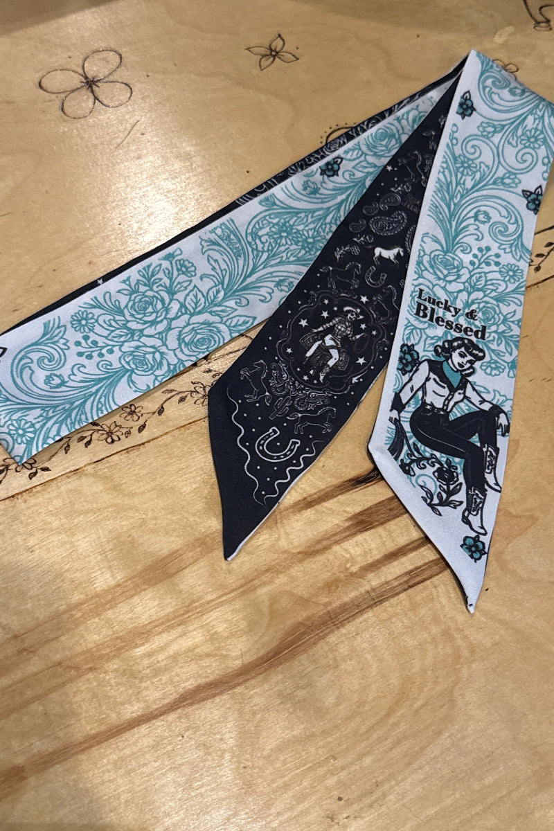 Trestles Clothing Company Pin Up Twilly scarf featuring a black and teal western print with a cowgirl illustration.